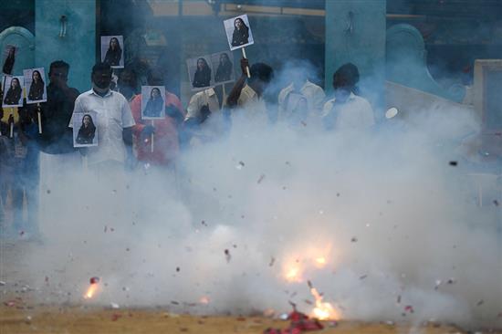 当地时间2021年1月20日，印度南部泰米尔纳德邦，美国当选副总统哈里斯祖籍地的民众在Thulasendrapuram村落内举起印有哈里斯头像的标牌，燃放鞭炮庆祝。人民视觉 图?